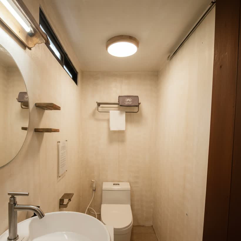 The bathroom’s basin, round mirror and toilet