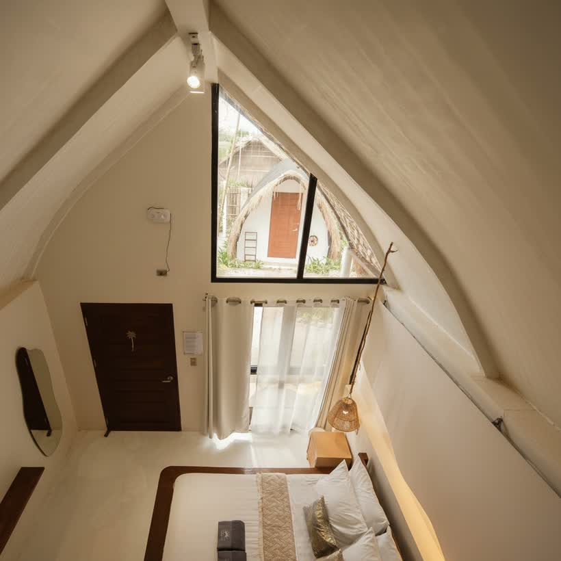 Looking down from the loft over the bed, door and gable window
